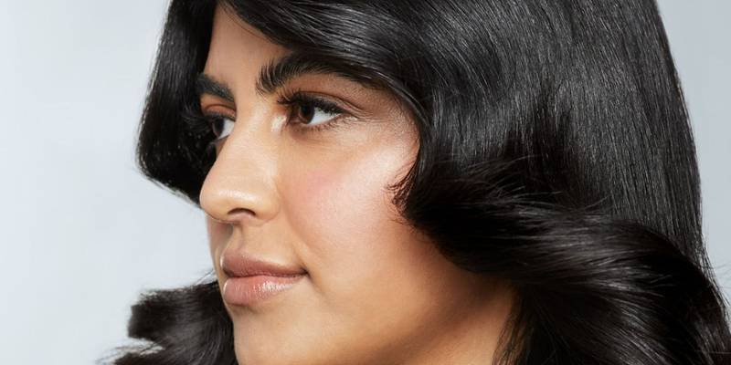 Profile of a model with glossy, bouncy black hair — Awapuhi Wild Ginger by Paul Mitchell