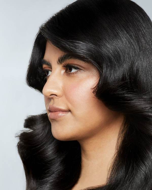 Profile of a model with glossy, bouncy black hair — Awapuhi Wild Ginger by Paul Mitchell