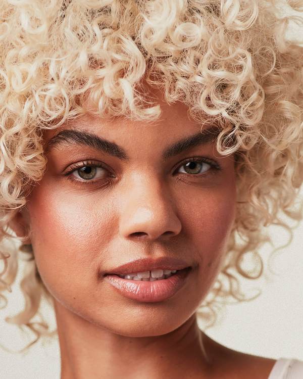 Close-up of a model with platinum blonde curls — Paul Mitchell Blonde