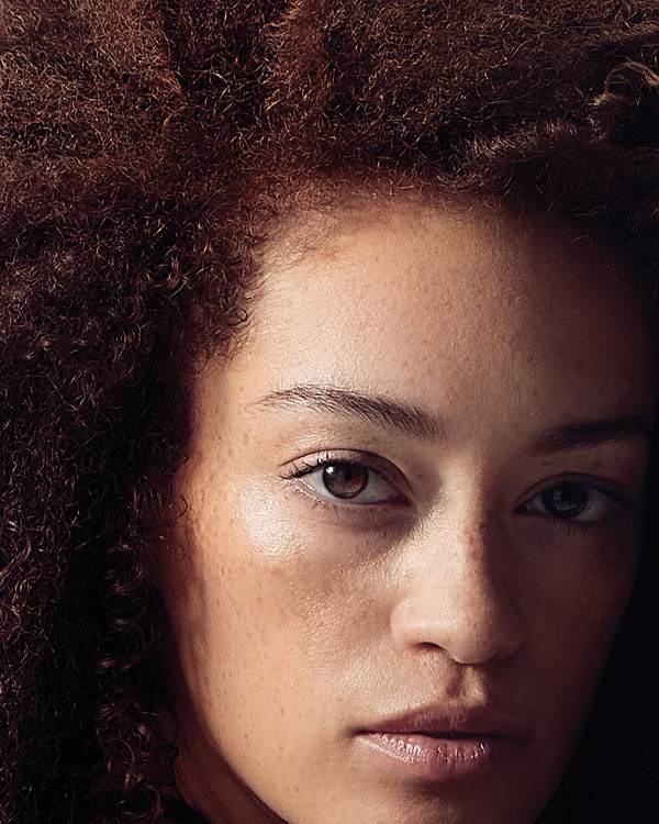Model with voluminous auburn-brown curls — Paul Mitchell Color Protect
