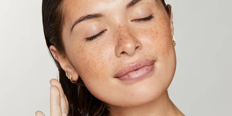 Model with freckles and sleek, wet-look hair, eyes closed — Awapuhi Wild Ginger by Paul Mitchell