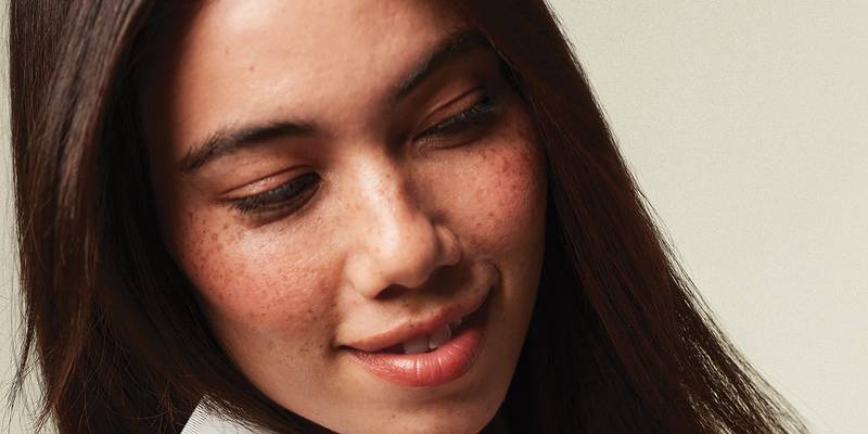 Model with long, straight dark hair and freckles — Paul Mitchell Smooth
