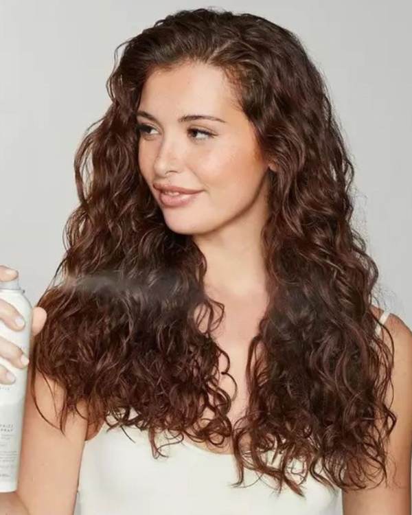 Model with long, glossy brown curls — Awapuhi Wild Ginger by Paul Mitchell